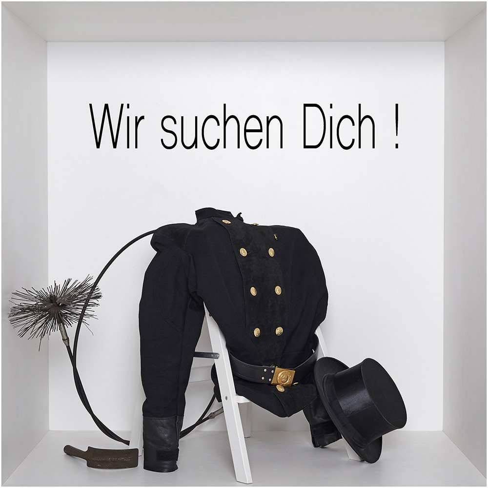 Ein Stuhl auf dem Schornsteinfeger-Kleidung liegt - Aufschrift Wir suchen dich!"